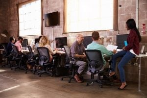 Team Of Designers Working At Desks In Modern Office