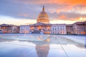 The United States Capitol building with the dome lit up at night.