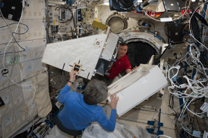 NASA astronauts Peggy Whitson and Jack Fischer move a new payload on to the NanoRacks External Platform to prepare for deployment from ISS. Photo: NASA.